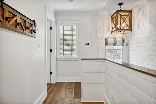 corridor featuring baseboards and wood finished floors