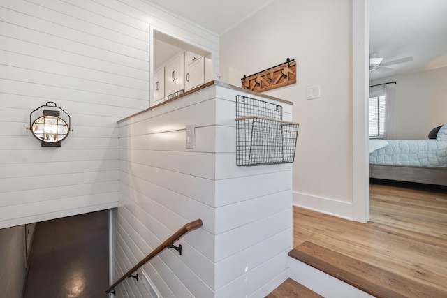 stairs featuring ceiling fan, baseboards, and wood finished floors