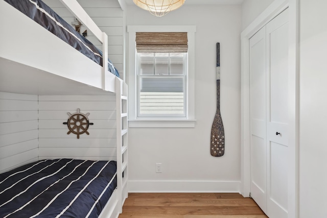 unfurnished bedroom featuring a closet, baseboards, and wood finished floors