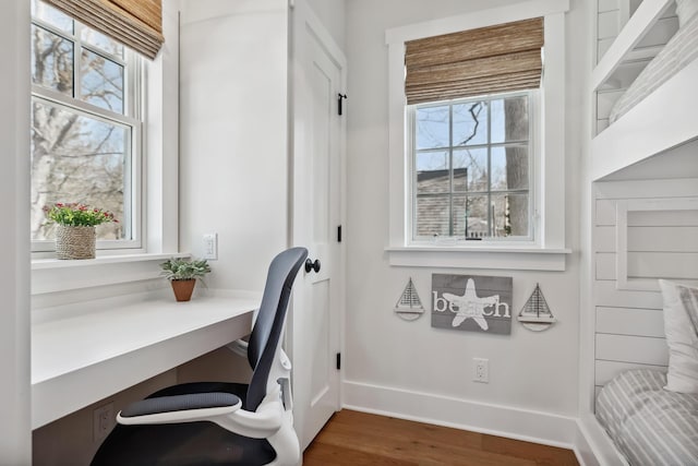 office with built in desk, plenty of natural light, baseboards, and wood finished floors