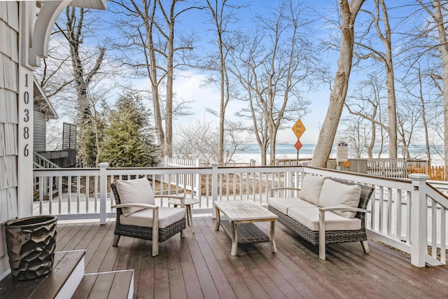 wooden terrace with fence, a water view, and an outdoor hangout area