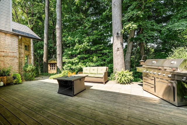 deck with a grill and an outdoor living space with a fire pit