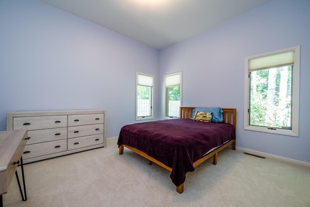 bedroom featuring visible vents and light carpet