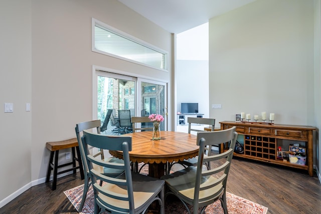 dining space with baseboards, high vaulted ceiling, and dark wood-style floors