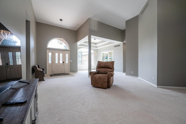 carpeted entrance foyer featuring visible vents, baseboards, and a towering ceiling