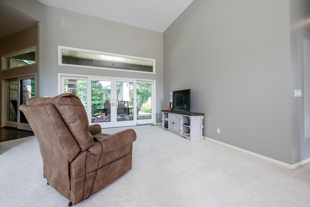 living room featuring carpet flooring, baseboards, and high vaulted ceiling