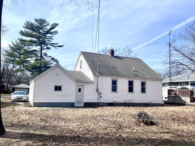 rear view of house featuring a chimney, a shingled roof, and a deck