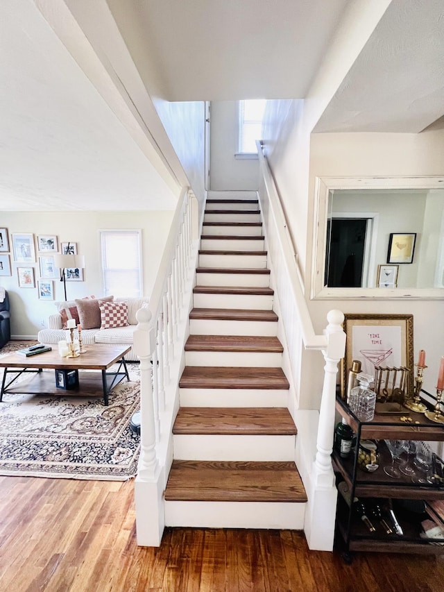 stairway with a wealth of natural light and wood finished floors