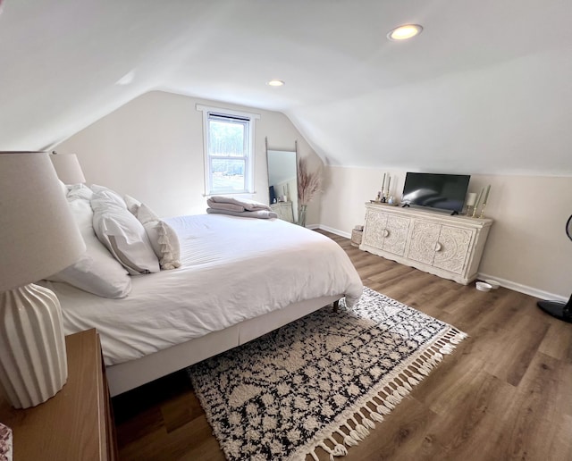 bedroom with recessed lighting, lofted ceiling, baseboards, and wood finished floors