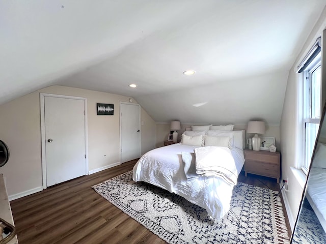 bedroom featuring baseboards, wood finished floors, and vaulted ceiling