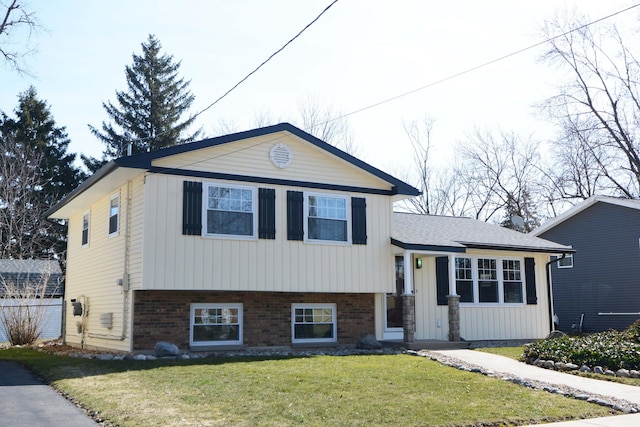 split level home with brick siding and a front lawn