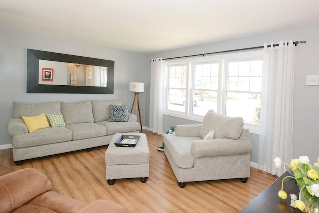 living area with light wood-style flooring and baseboards