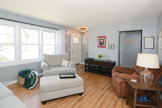 living area with visible vents, baseboards, and light wood-style floors