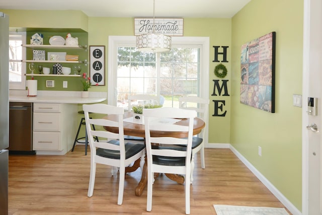 dining room with light wood-style flooring, baseboards, and built in study area