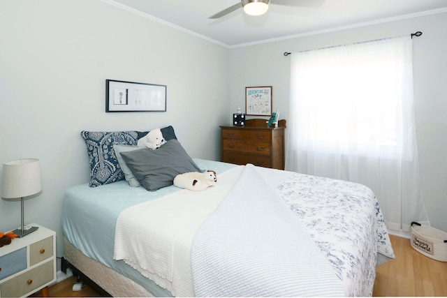 bedroom featuring ceiling fan, wood finished floors, and ornamental molding