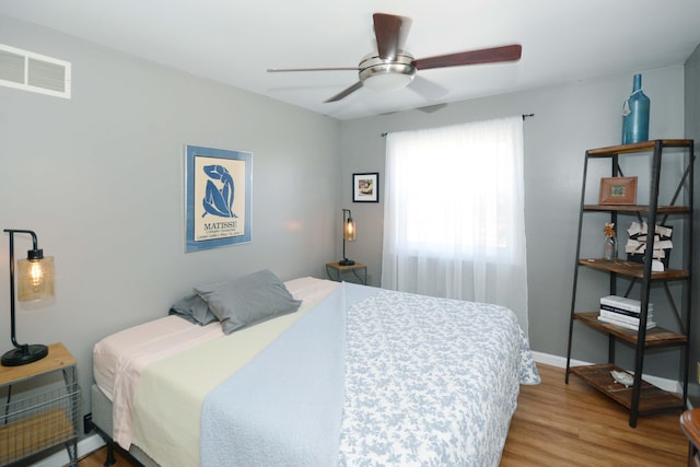 bedroom featuring ceiling fan, baseboards, visible vents, and light wood-type flooring