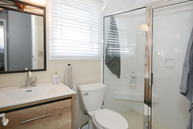 bathroom featuring toilet, a stall shower, and vanity