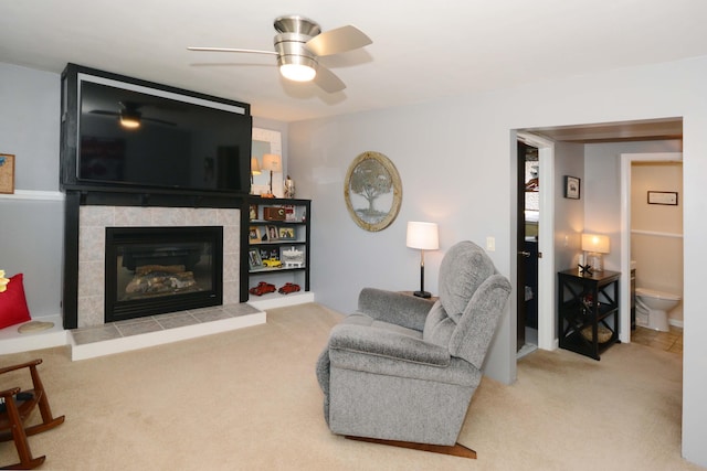 carpeted living room with a fireplace and ceiling fan