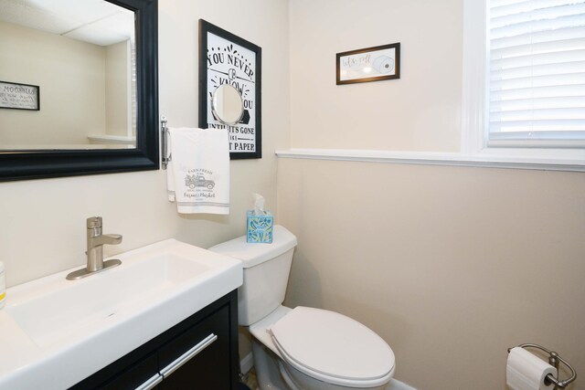 half bathroom featuring toilet and vanity