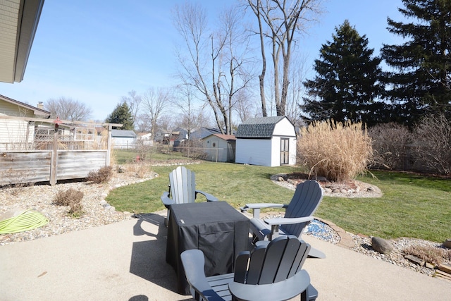 view of yard featuring a storage unit, a patio, an outbuilding, and fence