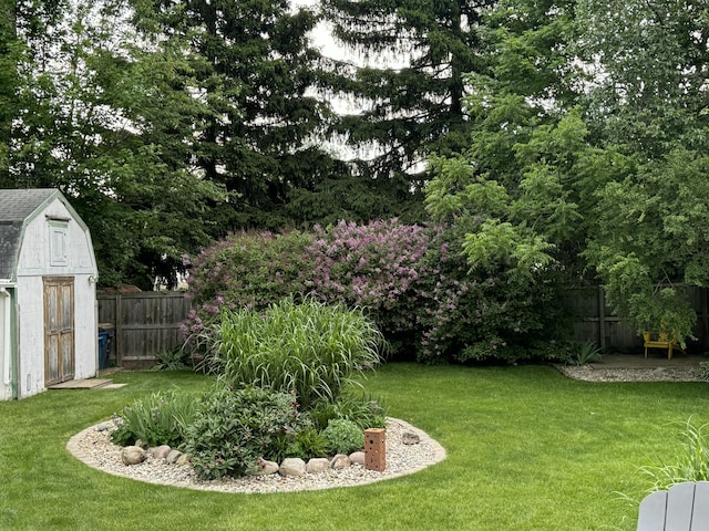 view of yard with a storage shed, an outbuilding, and a fenced backyard