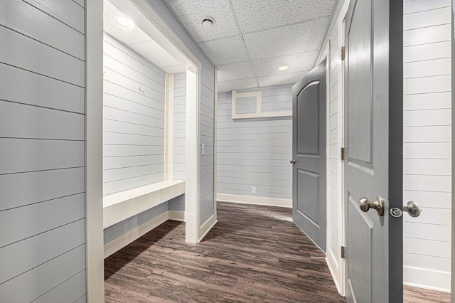 mudroom with baseboards, a paneled ceiling, dark wood-style floors, and wood walls