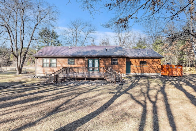 back of house featuring metal roof and a wooden deck