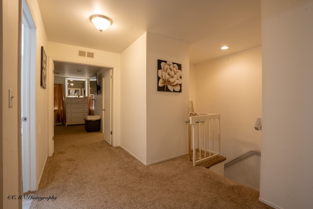 hall featuring recessed lighting, an upstairs landing, visible vents, and carpet floors