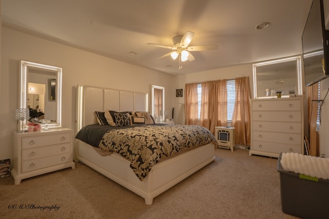 bedroom with light carpet and a ceiling fan