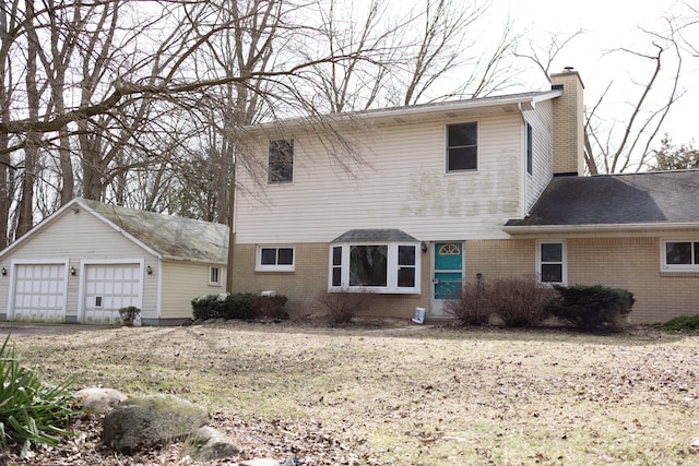 view of front facade with a garage, an outbuilding, brick siding, and a chimney