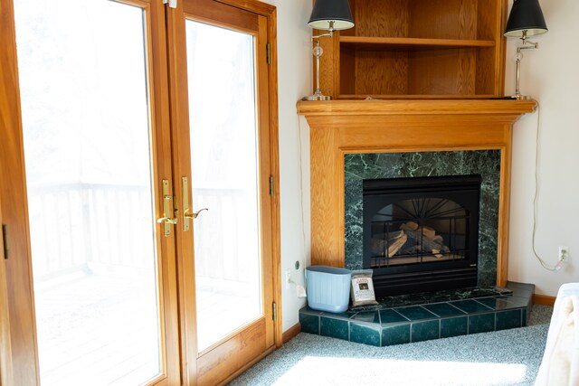 room details with french doors, baseboards, and a tile fireplace