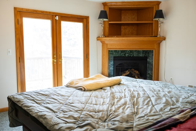 bedroom featuring a high end fireplace, carpet, and access to outside