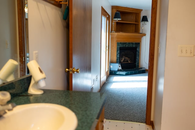 bathroom featuring a high end fireplace and a sink