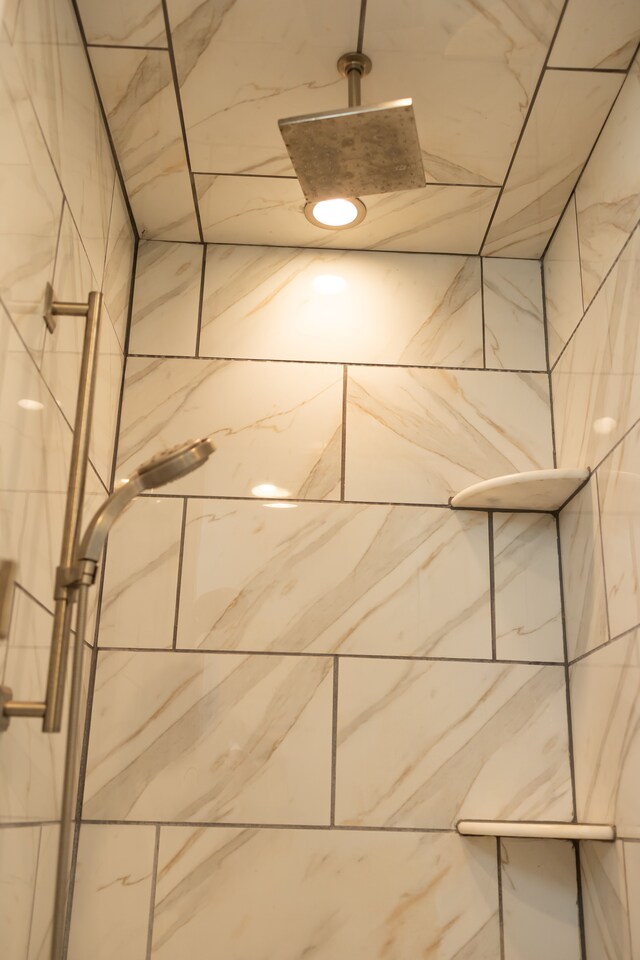 interior details featuring a tile shower