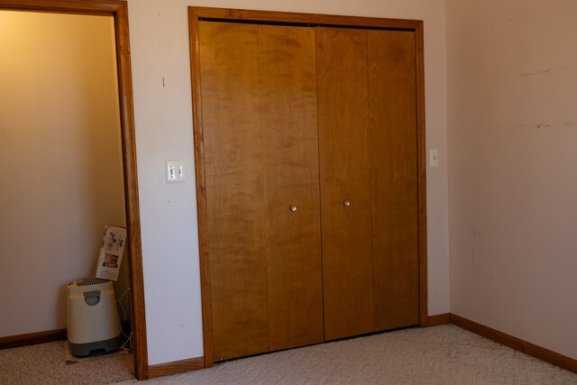 unfurnished bedroom with carpet, baseboards, and a closet