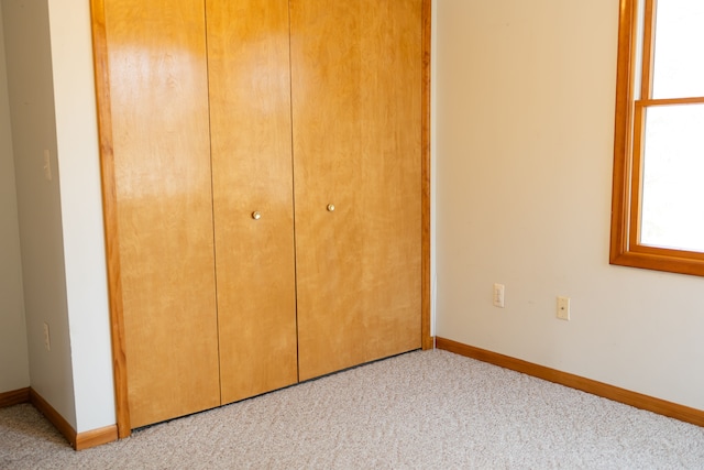 unfurnished bedroom featuring a closet, baseboards, and carpet