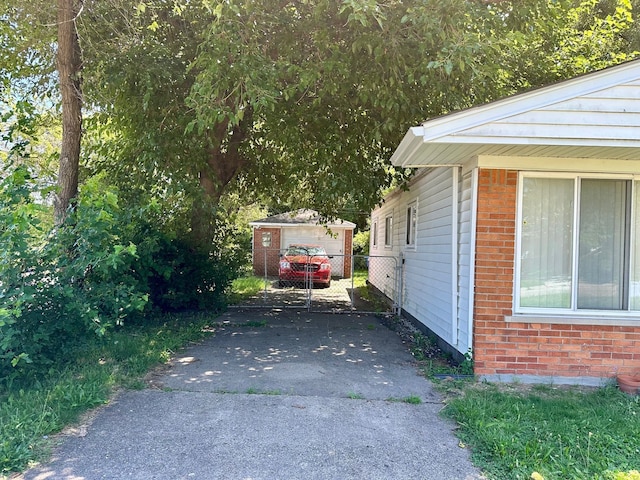 view of side of home featuring an outbuilding, fence, and brick siding