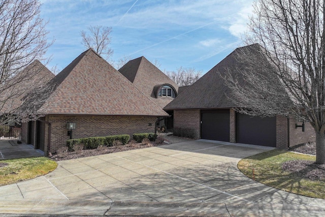 view of front of home with an attached garage, brick siding, and a shingled roof