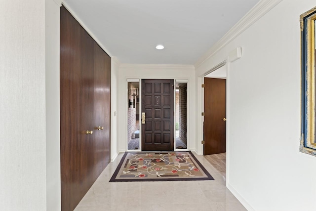 foyer featuring crown molding and baseboards