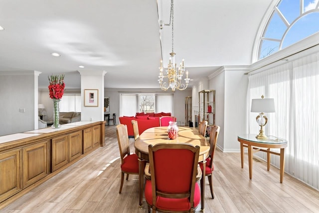 dining space with an inviting chandelier, light wood finished floors, and ornamental molding