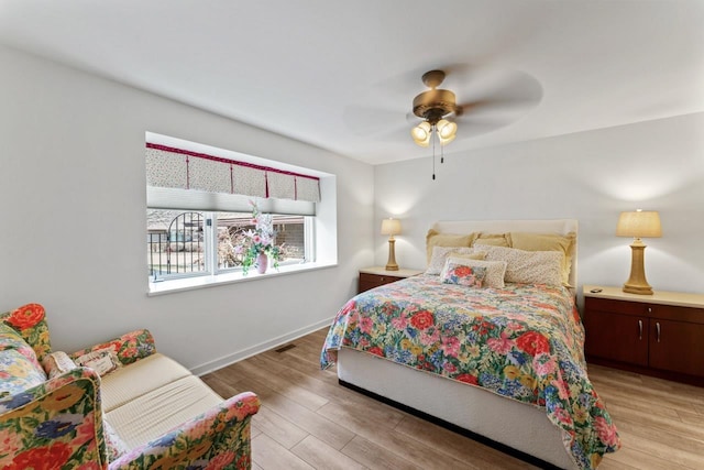 bedroom featuring ceiling fan, baseboards, and light wood-style flooring