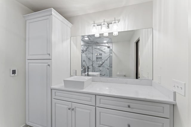 bathroom with a marble finish shower and vanity