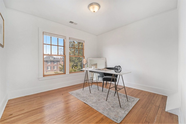 home office with visible vents, ornamental molding, baseboards, and wood finished floors