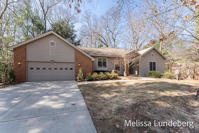 single story home featuring a garage, brick siding, and concrete driveway