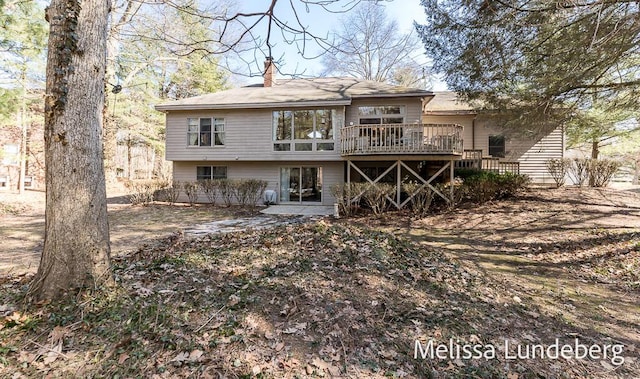 back of house featuring a chimney and a wooden deck