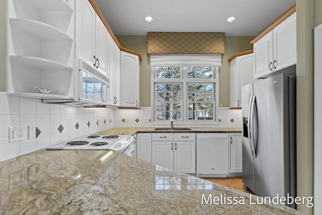 kitchen featuring open shelves, white appliances, light stone counters, and white cabinets