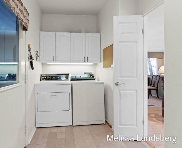 washroom featuring light wood-style flooring, cabinet space, independent washer and dryer, and baseboards