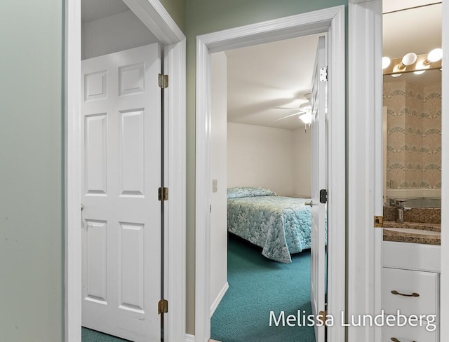 corridor with a sink and carpet