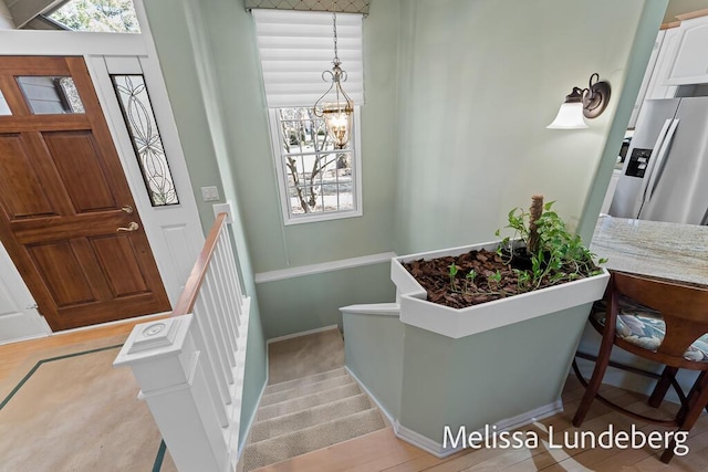 entryway featuring a notable chandelier and stairs