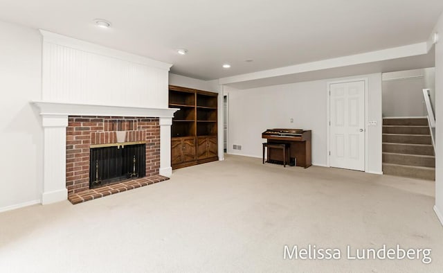 unfurnished living room featuring visible vents, recessed lighting, stairway, carpet floors, and a brick fireplace